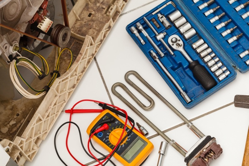 Engineer repairing a washing machine in Swiss Cottage